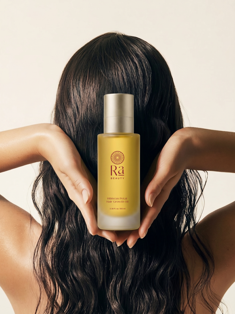 Ra Beauty Hibiscus Petal Hair Growth Oil held up by model with long dark hair